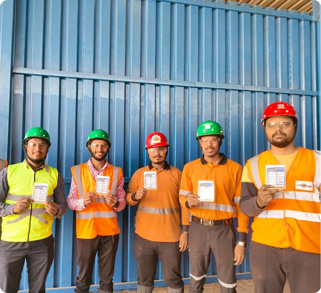 Safety Compliance Officers - Three safety professionals in PPE discussing blueprints at industrial site